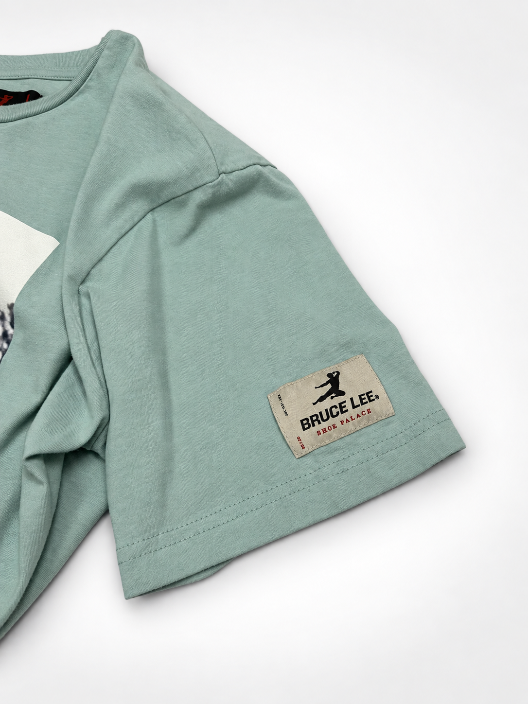 Close-up view of neckline and shoulder on mint Bruce Lee x Shoe Palace T-shirt