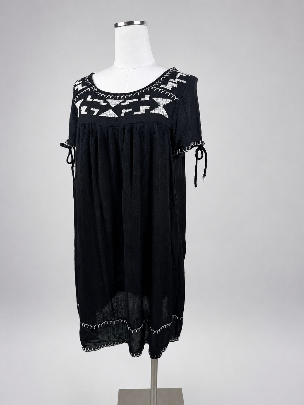 World Market black babydoll dress front view with white geometric embroidery