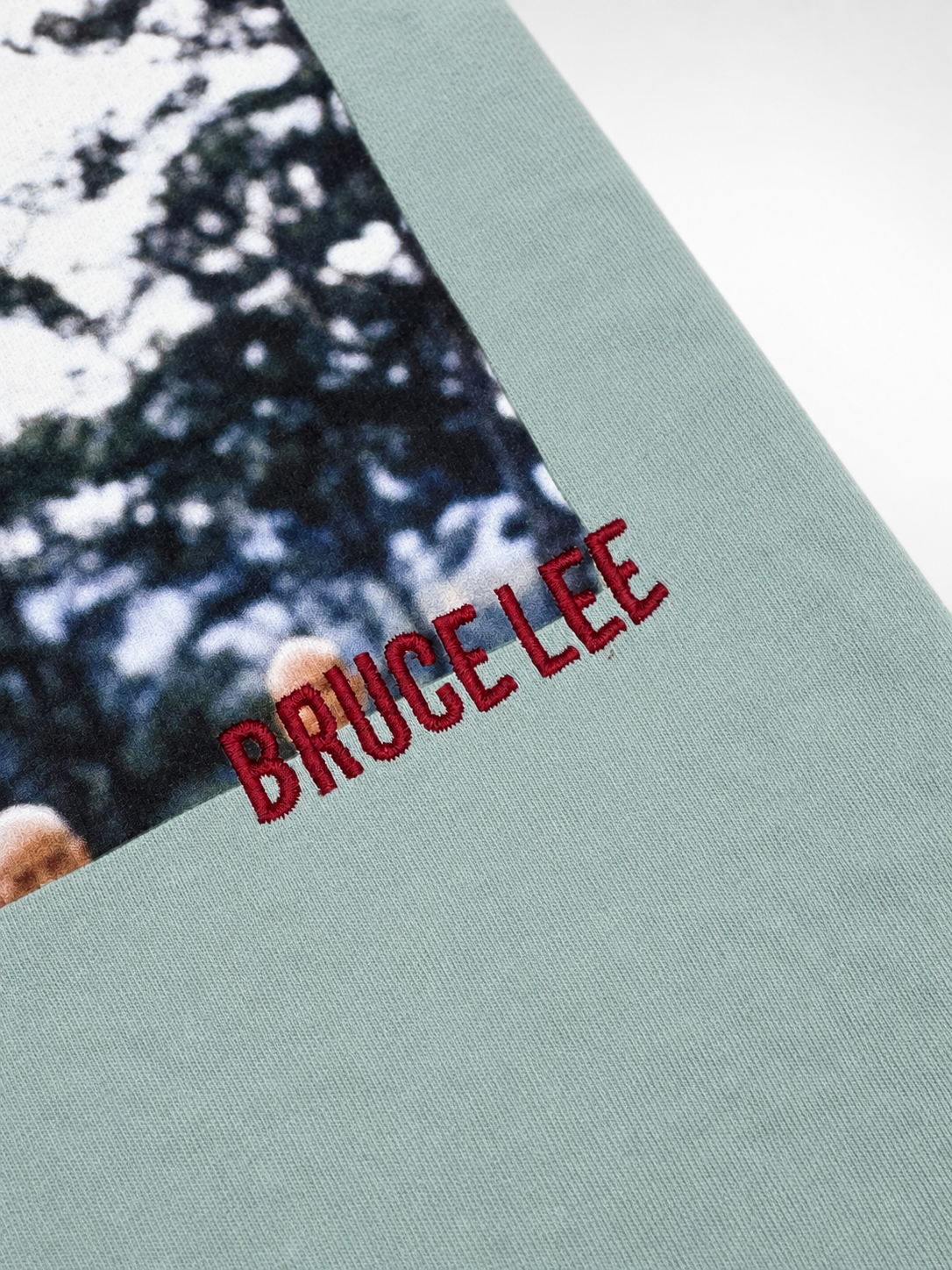 Back view of mint Bruce Lee x Shoe Palace T-shirt with photo and red embroidered graphics