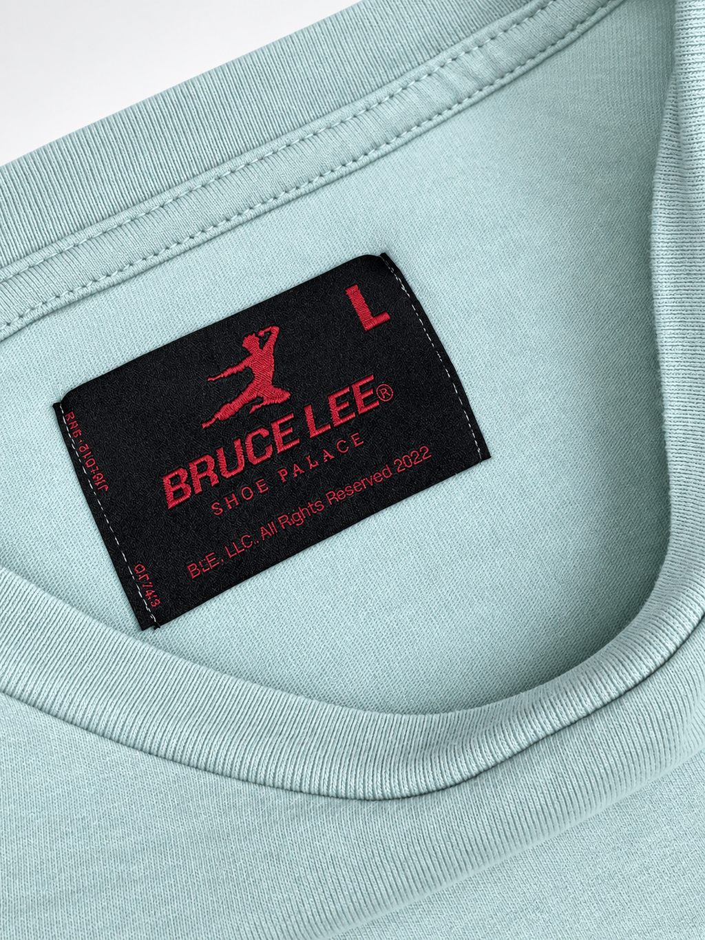 Close-up view of Bruce Lee photo graphic on mint Shoe Palace T-shirt