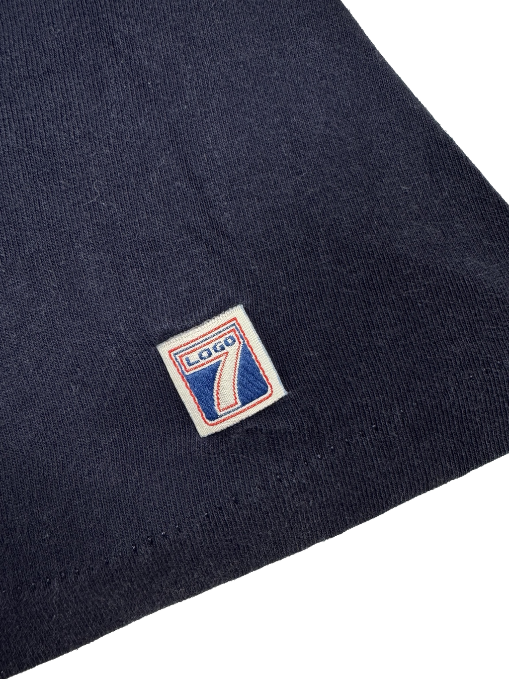 Close-up view of compass and baseball graphic on navy Mariners T-shirt made in USA