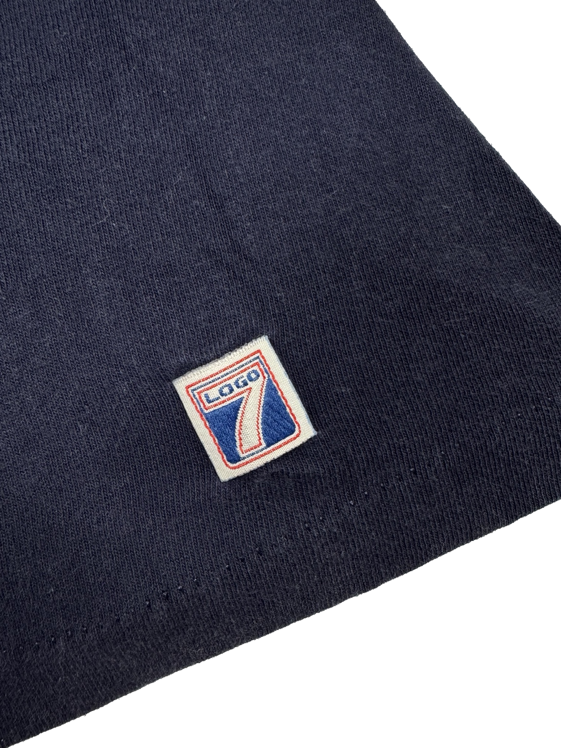 Close-up view of compass and baseball graphic on navy Mariners T-shirt made in USA
