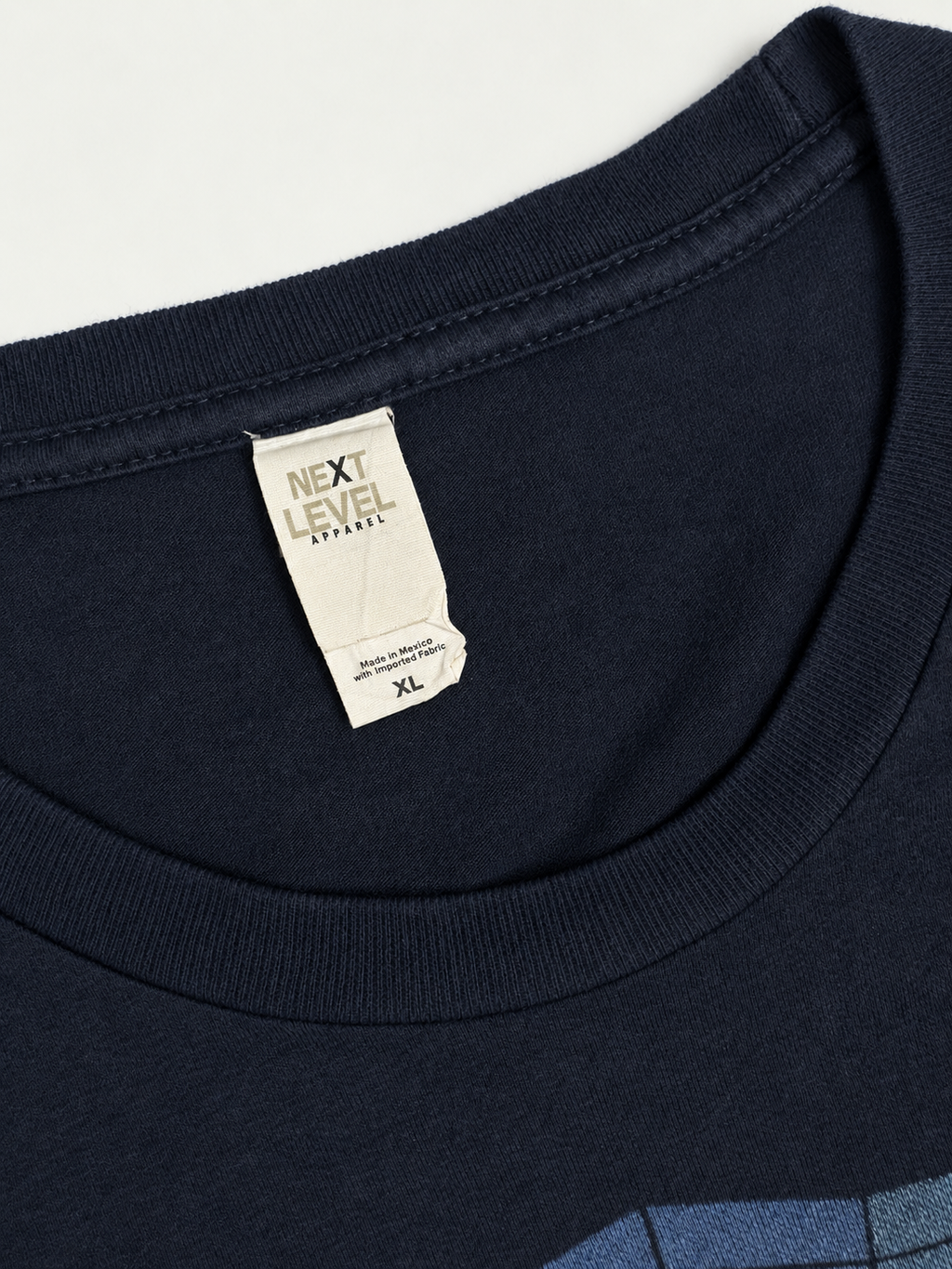 Next Level Apparel neck label showing XL size inside the navy Muse crewneck T-shirt