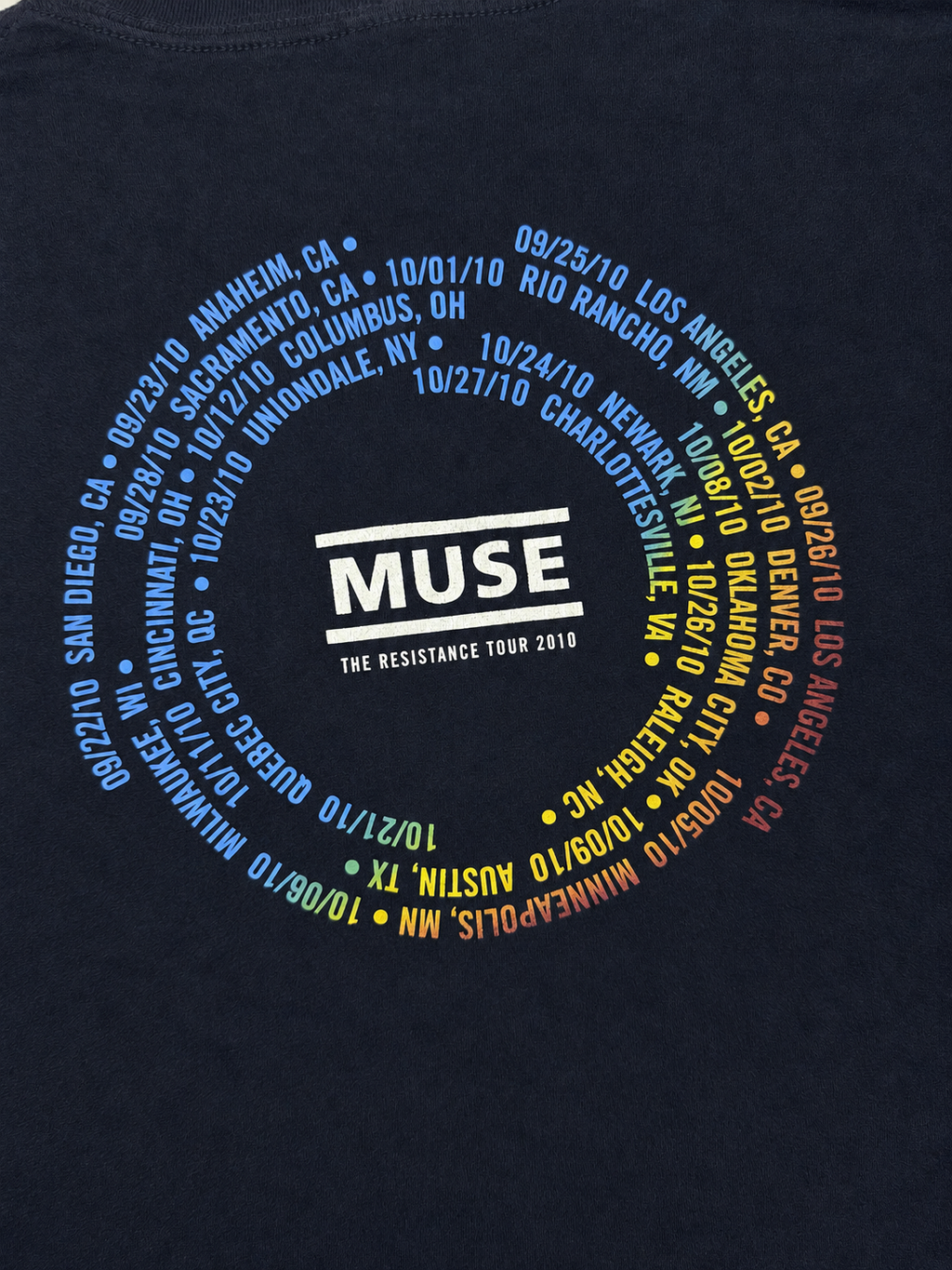 Close-up of Muse The Resistance Tour 2010 back print with colorful concert dates arranged around the band logo