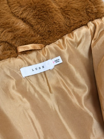 LUSH brand label and size medium tag inside the copper faux fur jacket against its tan lining.