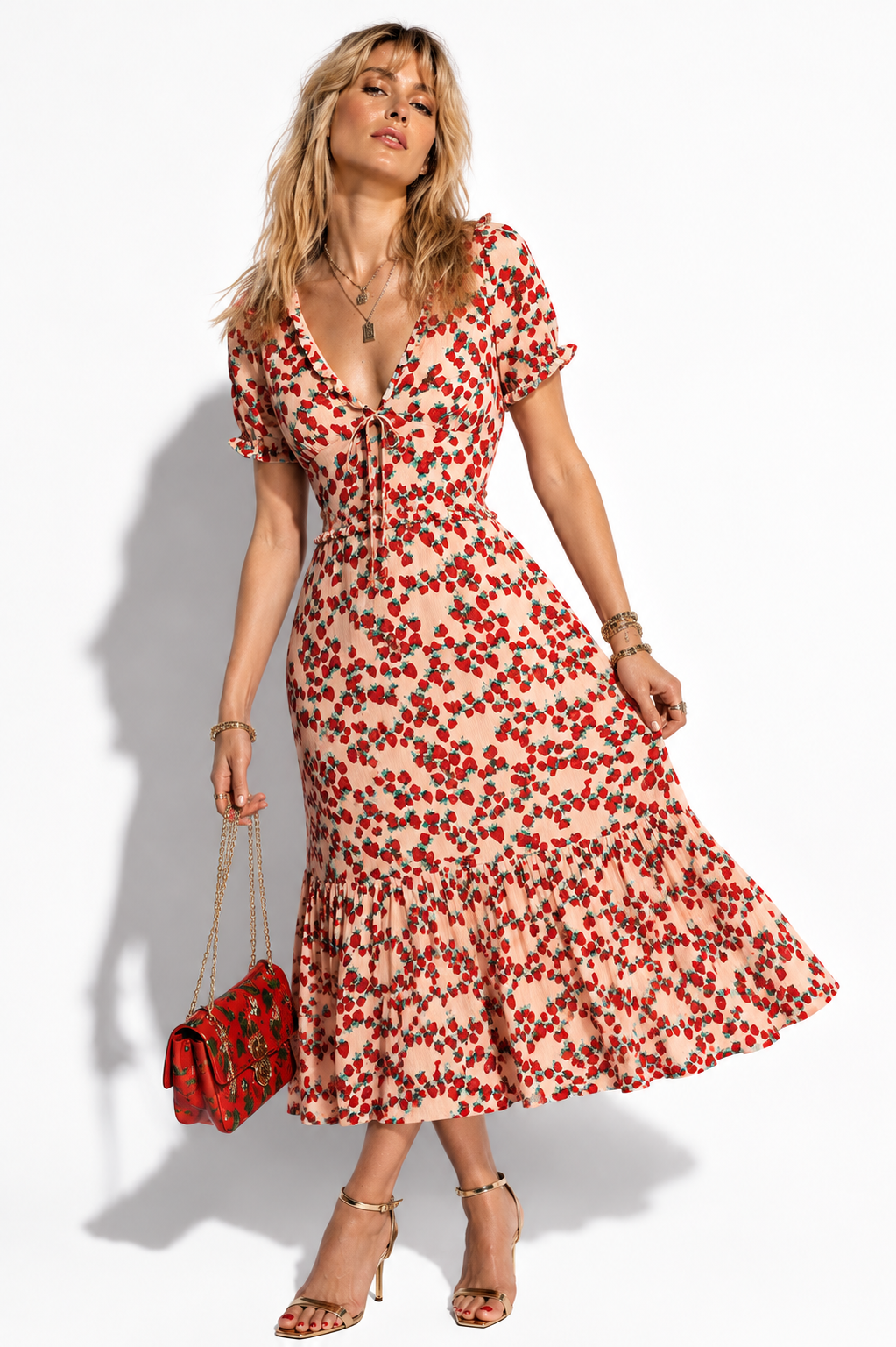 Model wearing Betsey Johnson blush strawberry print tiered midi dress