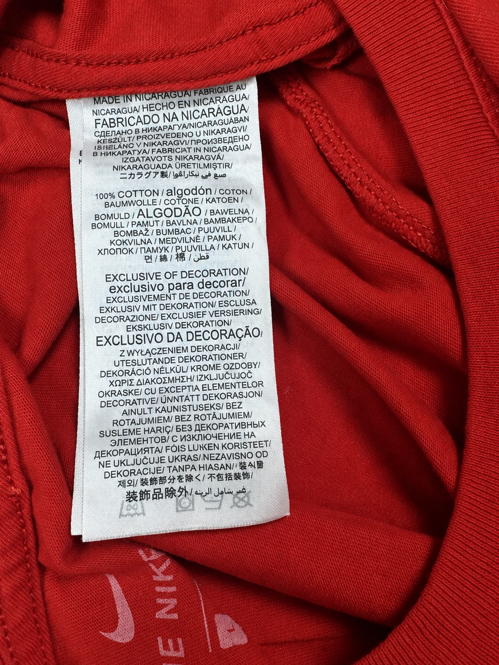 Nike fabric label showing 100 percent cotton inside red T-shirt